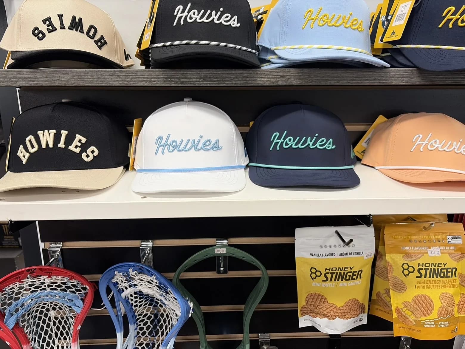 Howies hats, lacrosse heads, and Honey Stinger waffles on the pro shop wall at Wheelhouse